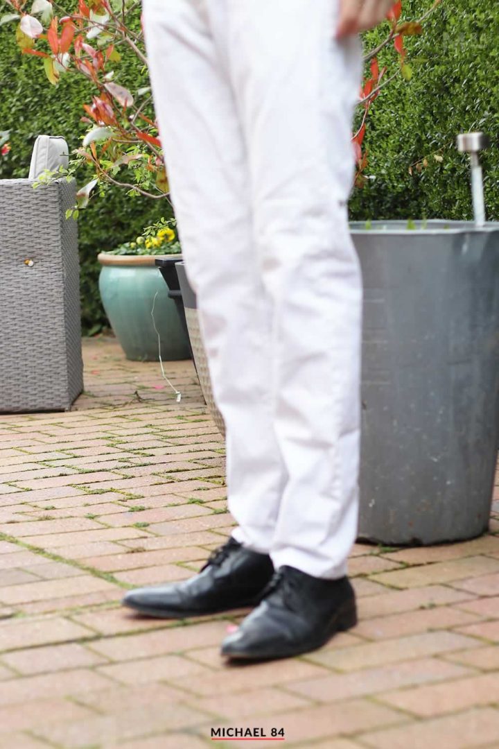 Wearing a white shirt, a black tie, gray pants, leather shoes, a young  handsome black guy is standing against a wall outside a gate, deeply  thinking Stock Photo - Alamy